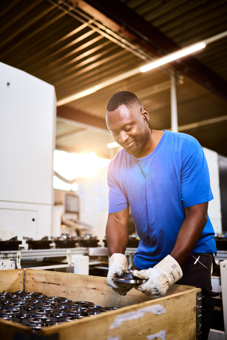 Dieses Industriefoto zeigt einen Mitarbeiter eines Industrieunternehmens beim Packen einer Kiste.