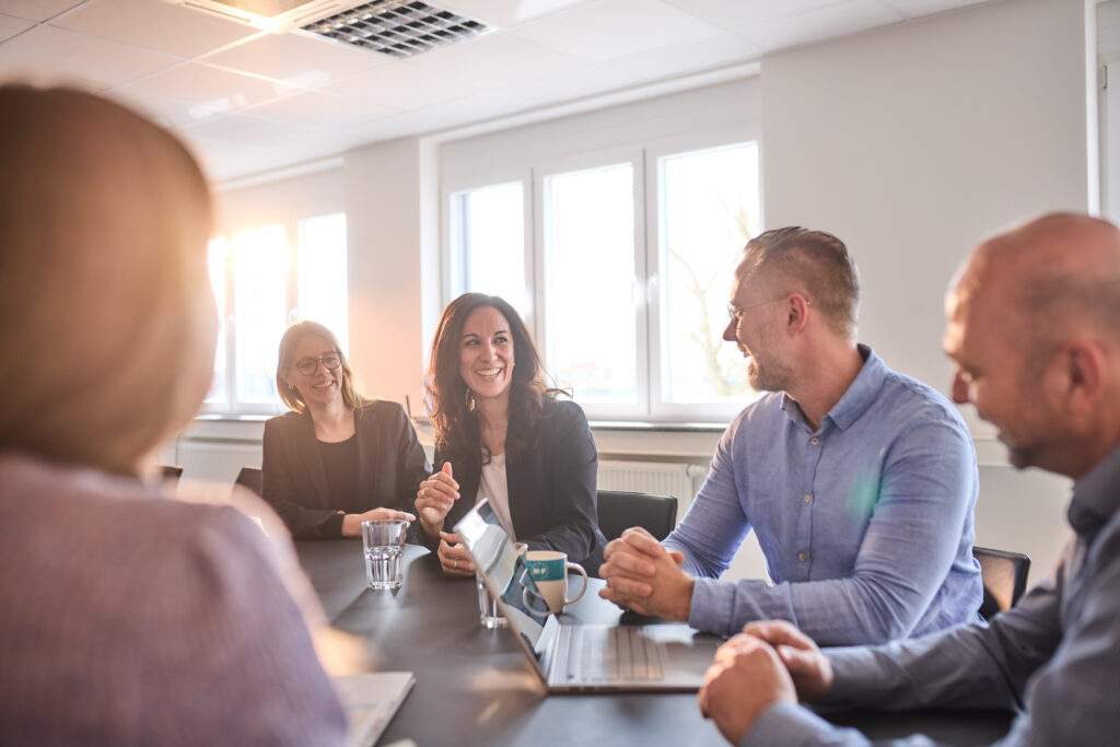Auf diesem Businessfoto ist eine gut gelaunte Meetingsituation abgebildet.