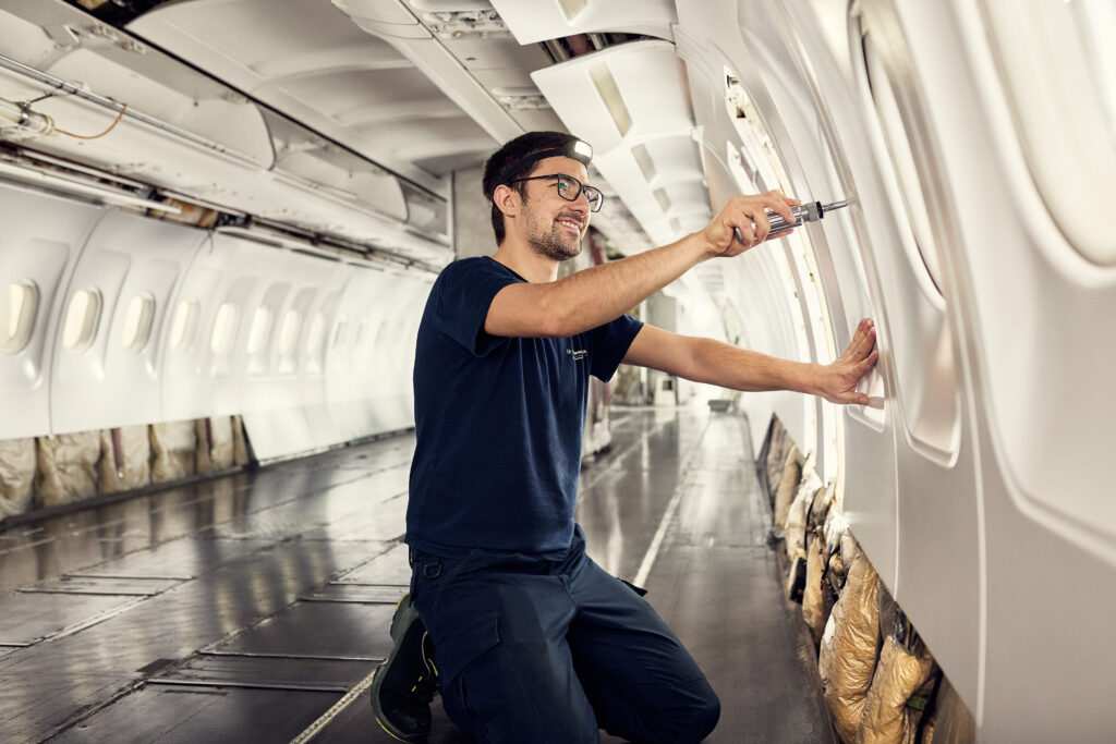 Industriefoto eines Flugzeugmechanikers in der Kabine