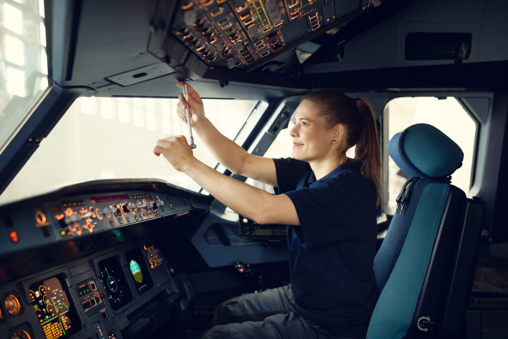 Employer Branding Foto einer jungen Technikerin in einem Flugzeugcockpit