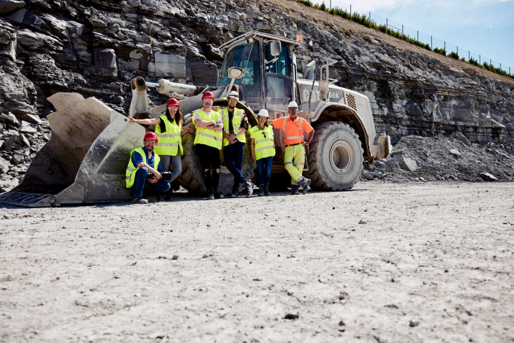 Teamfoto bei einem Industriefotoshooting vor einem Radlader.