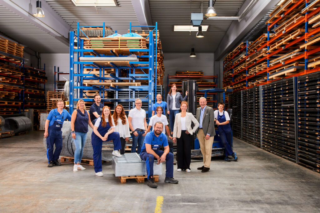 Dieses Gruppenfoto zeigt die Mitarbeitenden eines Betriebes inmitten ihrer Halle.