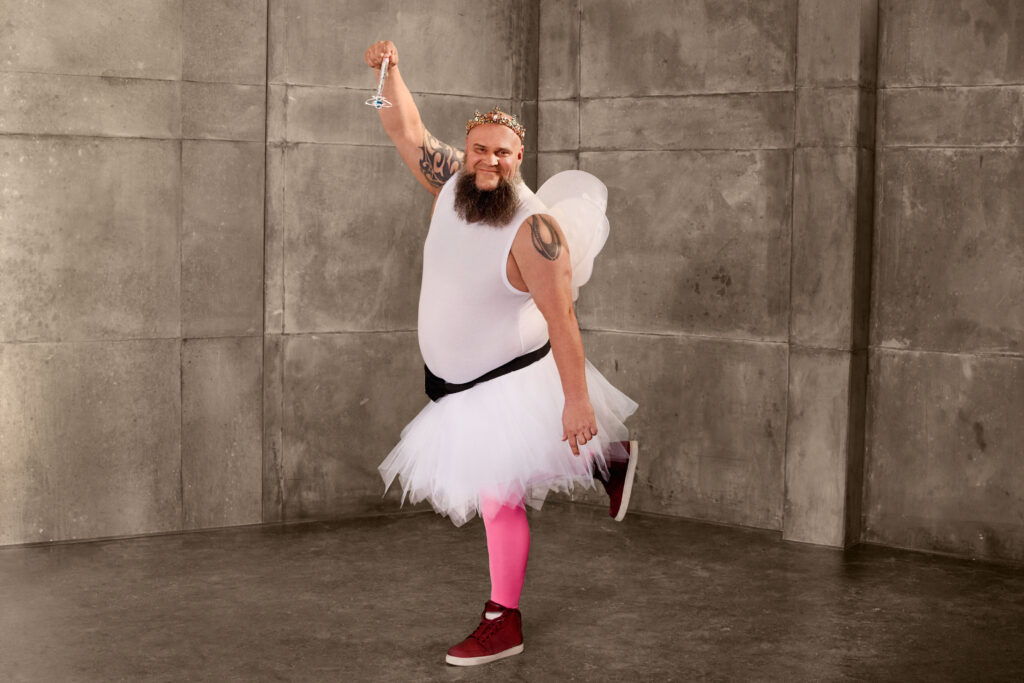 Ein Rocker ist verkleidet als Zahnfee und zeigt mit dem Zauberstab in die Kamera.