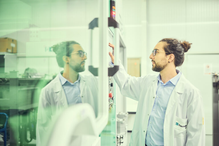 Auf diesem Industriefoto bedient ein Mitarbeiter des Fraunhofer Instituts eine Maschine.