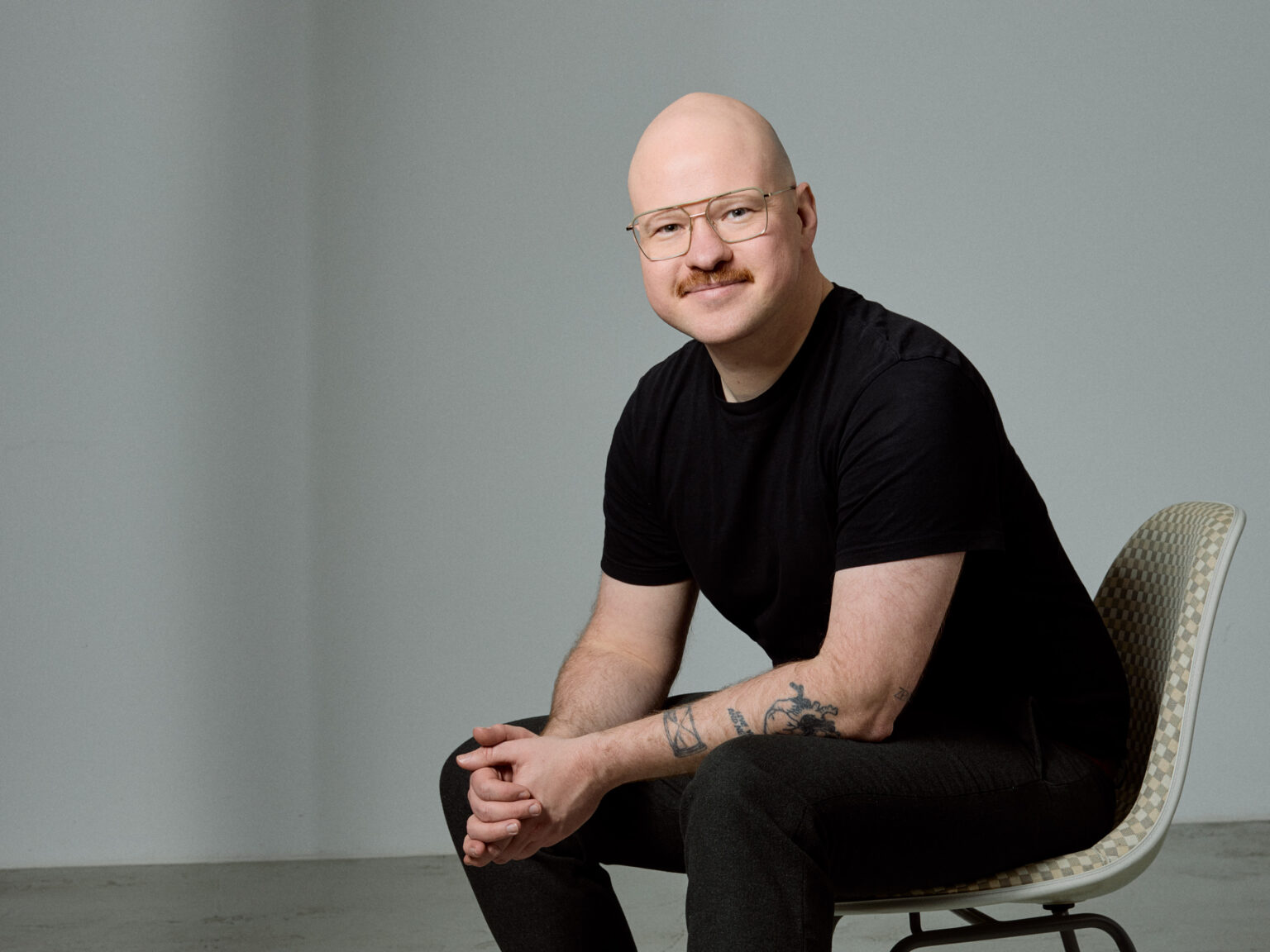 Portraitfoto von Hendrik Lüders mit verschränkten Armen vor einer weißen Wand.