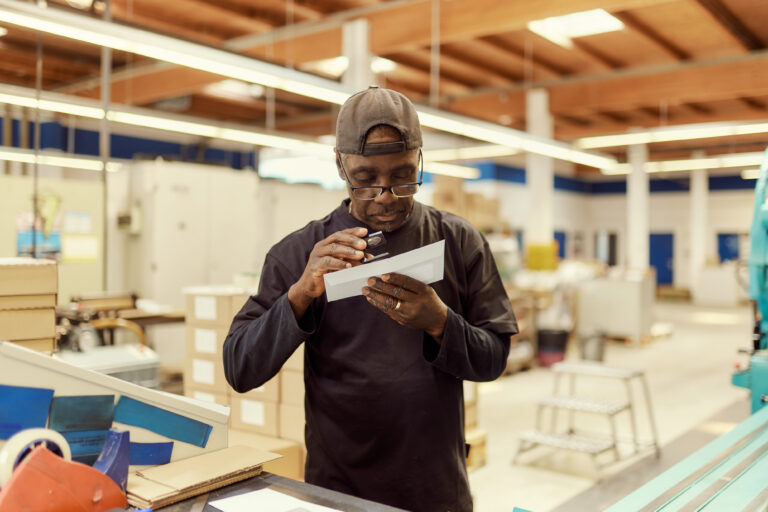 Ein Steinmetz Mitarbeiter untersucht einen Briefumschlag.